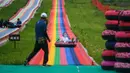 Seorang anak bermain seluncuran di sebuah kawasan resor di Kota Jilin, Provinsi Jilin, China pada 19 Juli 2020. Arena ski di kawasan resor itu diubah menjadi ladang bunga, seluncuran, dan beragam proyek pariwisata rekreasi lainnya guna menarik wisatawan pada musim panas. (Xinhua/Yan Linyun)