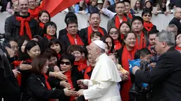 Jemaat dari China menyambut Paus Fransiskus untuk bersalaman saat audiensi umum mingguan di Lapangan Santo Petrus, di Vatikan (18/4). (AP/Gregorio Borgia)