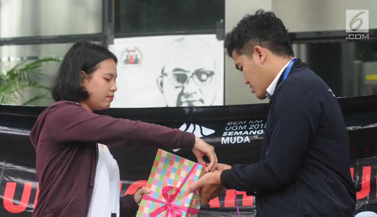 Presiden BEM KM UGM Obed Kresna Widyapratistha (kanan) menyerahkan kado kepada perwakilan Biro Humas KPK Brigita Simbolon di Gedung KPK Jakarta, Senin (10/12). Aksi simpatik ini untuk memperingati Hari Anti Korupsi Sedunia. (Merdeka.com/Dwi Narwoko)