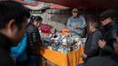 Seorang pedagang berteriak menjual barang dagangannya di pasar di Beijing (20/11). (AFP Photo/Nicolas Asfouri)
