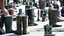 Peternak sapi meletakkan sepatu boots saat aksi protes di depan gerbang Brandenburg, Berlin, Jerman, Senin (30/5).  Mereka menuntut harga produk susu yang lebih adil bagi para peternak. (REUTERS/Fabrizio Bensch)