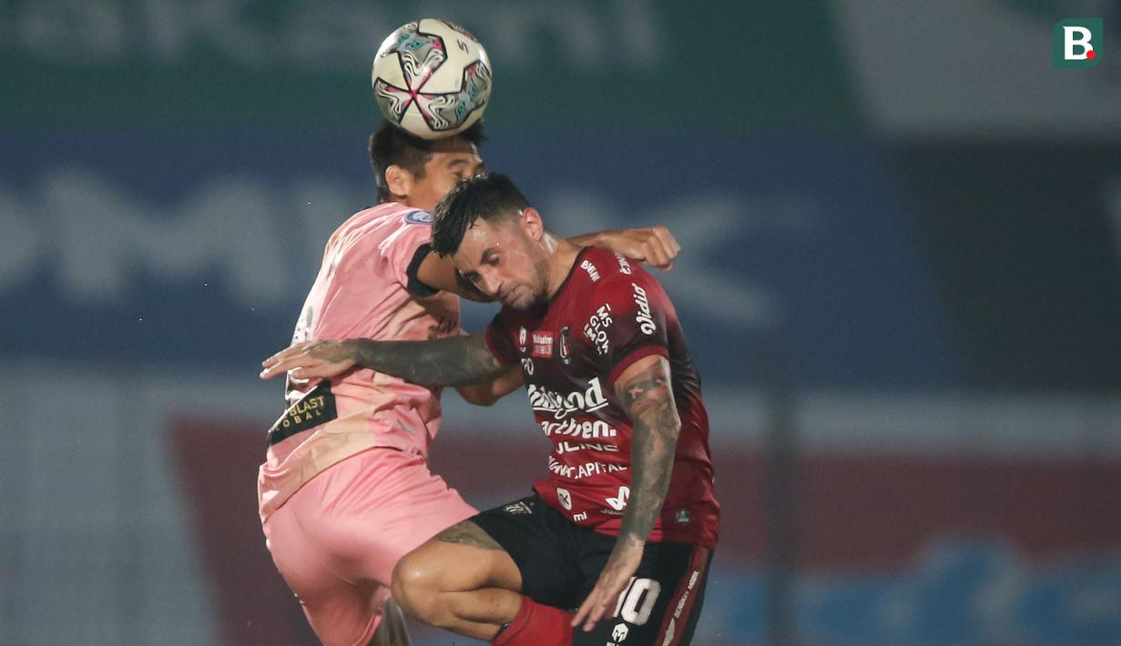 Pemain Bali United, Stefano Lilipaly (kanan) berduel udara dengan pemain Madura United, Guntur Ariyadi dalam laga pekan ke-16 BRI Liga 1 2021/2022 di Stadion Sultan Agung, Bantul, Kamis (09/12/2021). (Bola.com/Bagaskara Lazuardi)