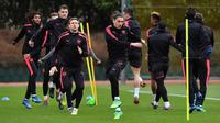 Para pemain Arsenal melakukan pemanasan selama latihan di London Colney Arsenal, Inggris (4/4). Arsenal akan bertanding melawan wakil Rusia, CSKA Moscow pada leg pertama babak perempat final Liga Europa. (AFP Photo/Ben Stansall)