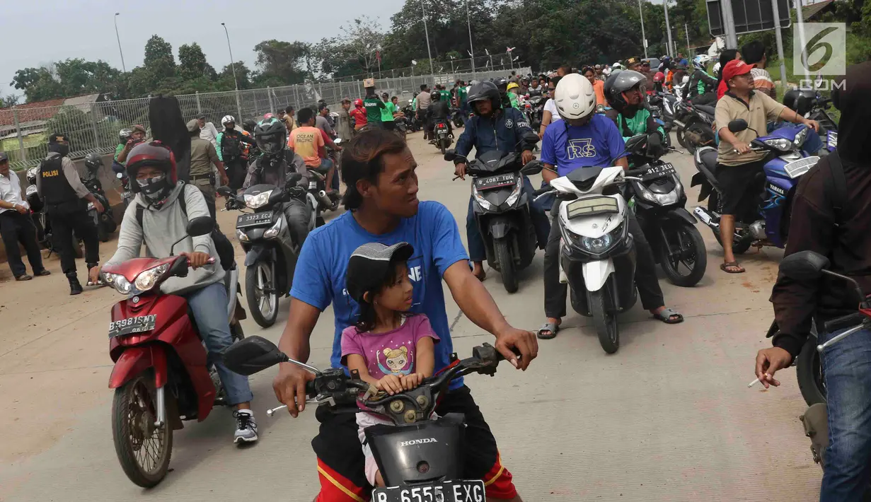 Warga berkerumun menyaksikan eksekusi bangunan rumah milik warga yang terdampak proyek Jalan Tol Cijago di kawasan Kukusan, Depok, Jawa Barat, Rabu (12/12). Di Kukusan, PN Depok kembali mengeksekusi 20 bidang lahan. (Liputan6.com/Immanuel Antonius)