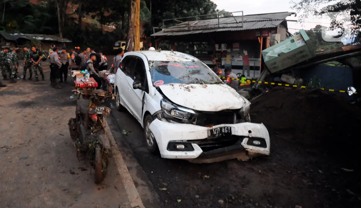 Mobil dan sepeda motor rusak akibat longsor akibat gempa bumi di jalan utama Cipanas-Cianjur kawasan Cugenang, Cianjur, Jawa Barat, Senin (21/11/2022). Longsor membawa sebuah angkot yang diduga berisi penumpang dan truk ke dalam jurang, evakuasi pun akan dilanjutkan esok hari. (merdeka.com/Arie Basuki)