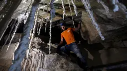 Anggota Pusat Penelitian Gua Universitas Hebrew, Efraim Cohen berdiri dekat stalaktit garam dalam Gua Malham di Gunung Sodom, Israel, Rabu (27/3). Gua garam yang besar adalah struktur geologi langka, ini karena garam sangat mudah larut di air. (REUTERS/Nir Elias)
