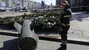 Seorang petugas pemadam kebakaran melihat pecahan rudal Tochka-U Ukraina di sebuah jalan di Donetsk di Ukraina timur, Senin, 14 Maret 2022. Militer Rusia mengatakan bahwa sedikitnya 20 warga sipil tewas oleh rudal balistik yang diluncurkan oleh pasukan Ukraina. (AP Photo/Alexei Alexandrov)