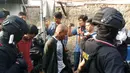 Petugas menggiring terduga pelaku dalam penggerebekan Kampung Boncos, Kota Bambu Selatan, Palmerah Jakarta Barat, Rabu (7/2). (Liputan6.com/ Ady Anugrahadi)
