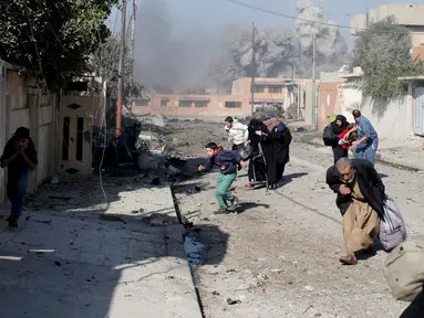 Sejumlah warga panik berlarian menyusul serangan udara yang dilakukan militan ISIS di kota Tahrir, Irak, 17 November 2016. (REUTERS/Goran Tomasevic)