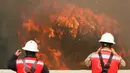Dua orang petugas melihat kebakaran besar yang melanda kota pantai Valparaiso di Chile, Senin (2/1). Api menghanguskan sedikitnya 100 rumah dan mendorong evakuasi pada sekitar 400 orang. (REUTERS/Rodrigo Garrido)
