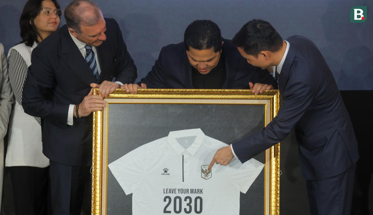 Ketua Umum PSSI, Erick Thohir (tengah) mendapatkan cendera mata kaos polo dari Chairman of CEO Kelme Global Clinten KE (kanan) dan Vice Chairman of Kelme Global, Borja Garcia Nieto (kiri) dalam acara perkenalan kerja sama yang berlangsung di Hotel Tribrata, Jakarta, Jumat (23/01/2026). (Bola.com/Bagaskara Lazuardi)