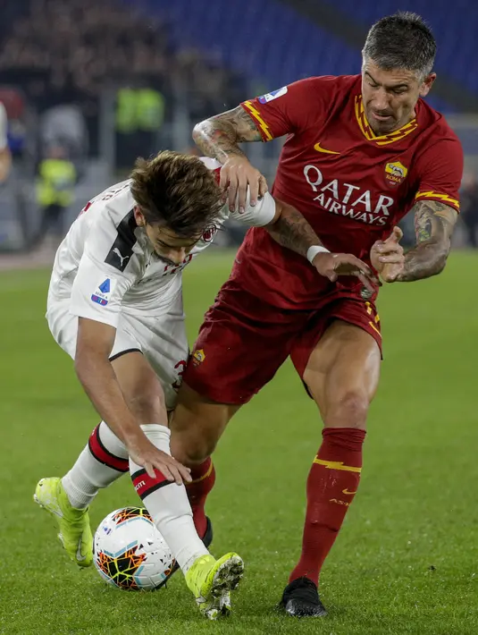 Gelandang AC Milan, Lucas Paqueta (kiri) berebut bola dengan bek AS Roma, Aleksandar Kolarov pada pertandingan Lanjutan Liga Serie A Italia di Stadion Olimpiade Roma (28/10/2019). AS Roma menang tipis 2-1 atas AC Milan. (AP Photo/Andrew Medichini)