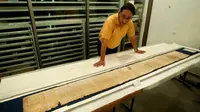 Bagian dari Gulungan Yesaya atau Isaiah Scroll, salah satu Gulungan Laut Mati atau Dead Sea Scrolls, diamankan di dalam gedung Shrine of the Book di Museum Israel di Yerusalem. (AP)