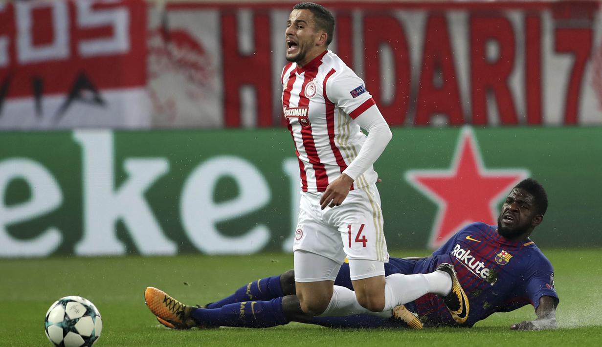 Bek Olympiakos, Omar Elabdellaoui, terjatuh saat berebut bola dengan bek Barcelona, Samuel Umtiti, pada laga Liga Champions di Stadion Karaiskakis, Selasa (31/10/2017). Barcelona bermain imbang 0-0 dengan Olympiakos. (AP/Petros Giannakouris)
