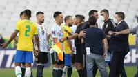 Pemain Brasil dan Argentina berbicara dengan otoritas kesehatan saat pertandingan kualifikasi Piala Dunia 2022 dihentikan di stadion Neo Quimica Arena di Sao Paulo (5/9/2021). Otoritas kesehatan Brasil menyebut empat pemain Argentina telah melanggar aturan karantina. (AP Photo/Andre Penner)