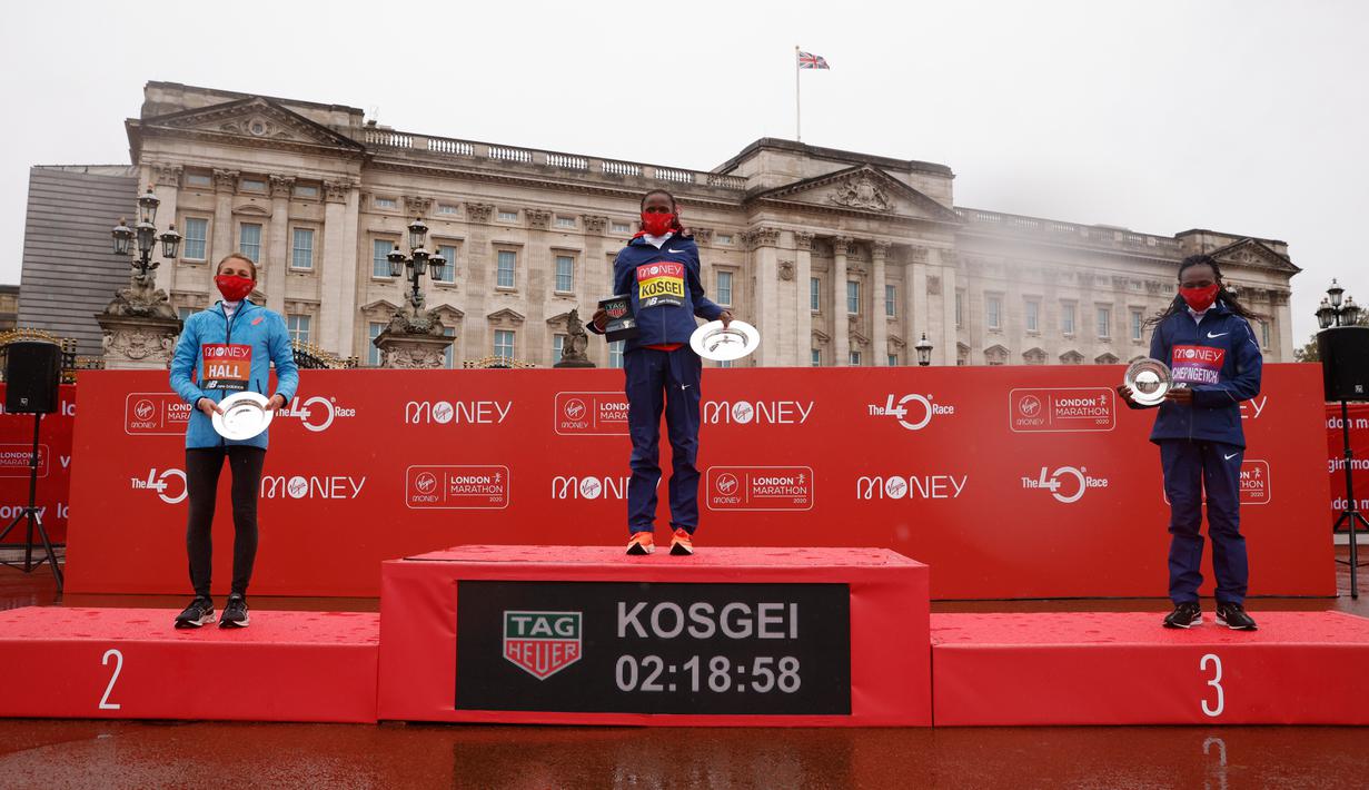 Brigid Kosgei dari Kenya (tengah) merayakan di podium setelah memenangkan London Marathon ke-40 kategori elit putri di London, Inggris, Minggu (4/10/2020). Juara bertahan Brigid Kosgei meraih kemenangan dalam dua jam 18,58 menit. (Richard Heathcote/Pool via AP)