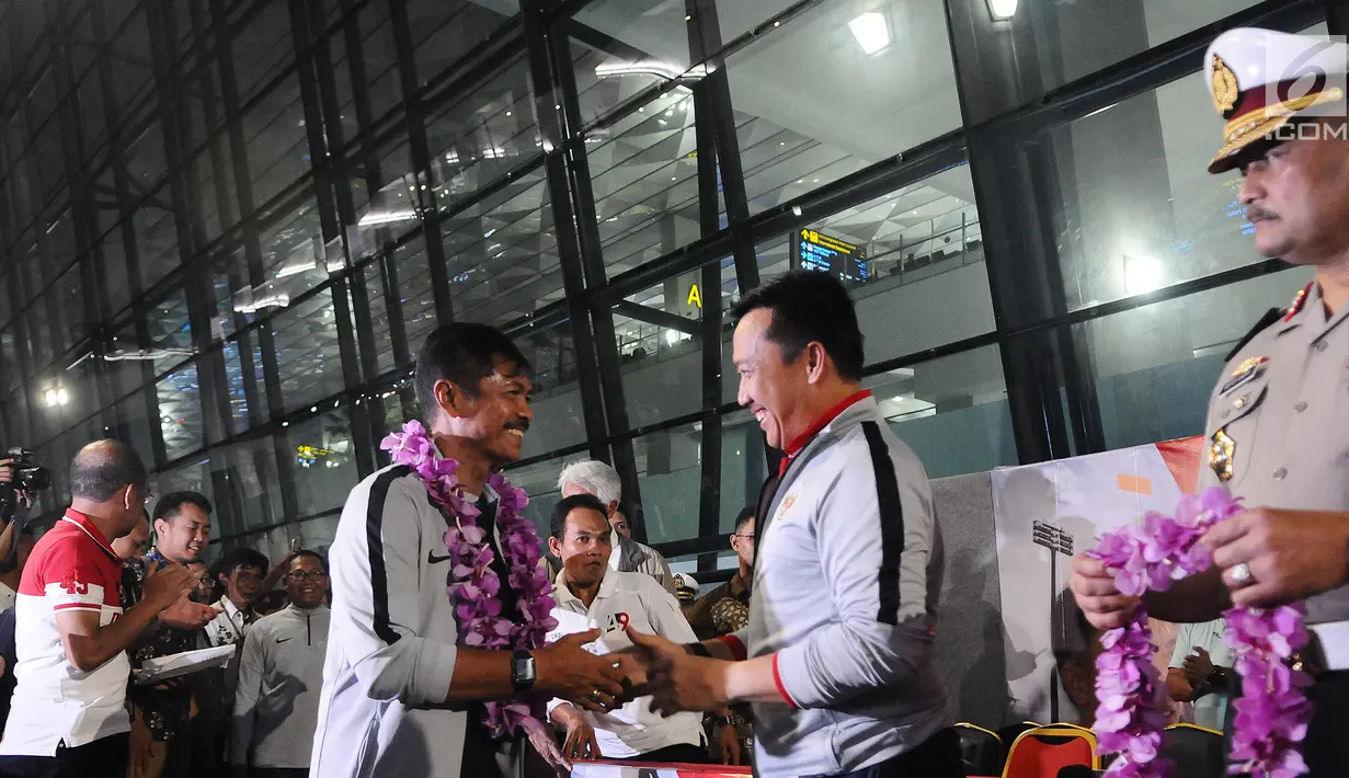 Menpora Imam Nahrawi memberikan selamat kepada pelatih Timnas Indonesia U-22 Indra Sjafri saat tiba di Bandara Soekarno Hatta, Tangerang, Rabu (27/2). Timnas tiba di tanah air usai menjuarai Piala AFF U-22 2019 di Kamboja. (Liputan6.com/Herman Zakharia)