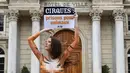 Model asal Brasil, Juliana Marques menunjukkan plakat dengan tulisan "Sirkus, penjara untuk binatang" saat melakukan aksi di Avignon, Prancis (11/2). Aksi tersebut ini untuk menyuarakan penolakannya terhadap pertunjukan sirkus. (AFP Photo / Boris Horvat)