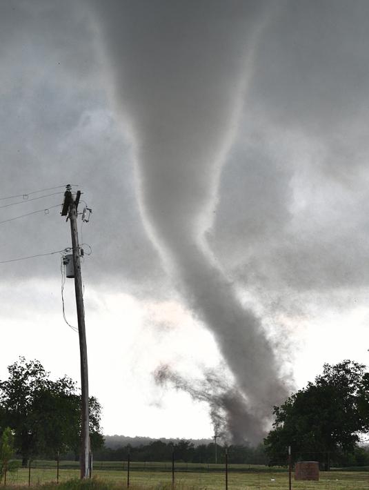 Sebuah tornado besar melewati daerah perumahan dari selatan Wynnewood, Kota Oklahoma, Senin (9/5). Tornado tersebut mendarat dengan cepat dan menghancurkan bangunan yang dilewatinya. (Josh EDELSON/AFP)