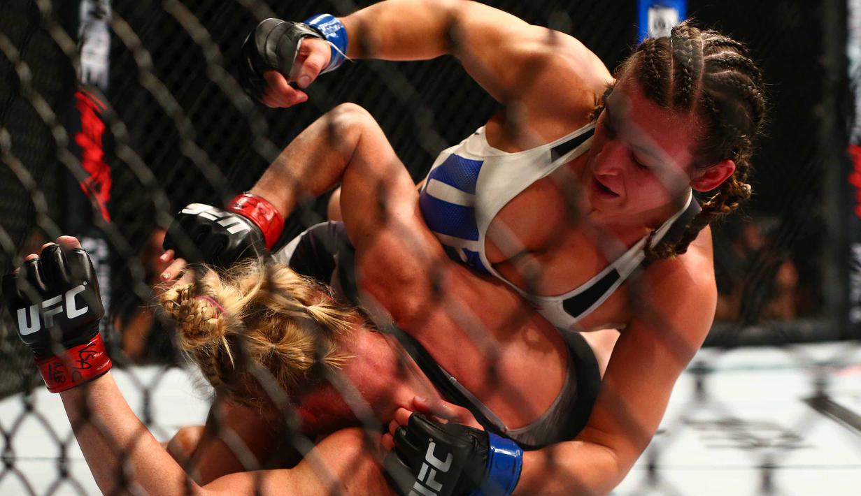 Petarung bebas, Miesha Tate menjatuhkan lawannya Holly Holm  pada ajang UFC 196 di MGM Grand Garden Arena, Las Vegas, Amerika Serikat, Minggu (6/3/2016)  (Reuters/Mark J. Rebilas-USA TODAY Sports)
