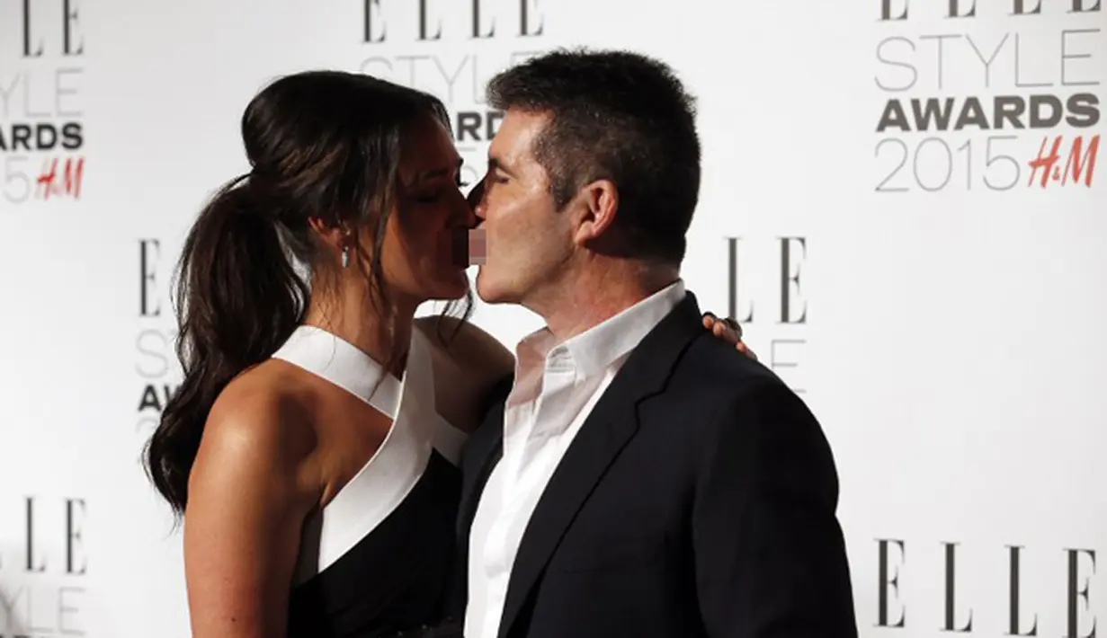 Produser musik, Simon Cowell dan pasangannya, Lauren Silverman menunjukkan kemesraan di red carpet Elle Style Awards 2015, London, Selasa (24/2). (AFP PHOTO/Justin Tallis)