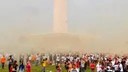 Suasana saat warga bermain serbuk warna-warni saat Festival Damai Millenial Road Safety di Monas, Jakarta, Minggu (23/6/2019). Serbuk warna-warni yang ditembakkan oleh meriam menambah kemeriahan Festival Damai. (merdeka.com/Iqbal Nugroho)