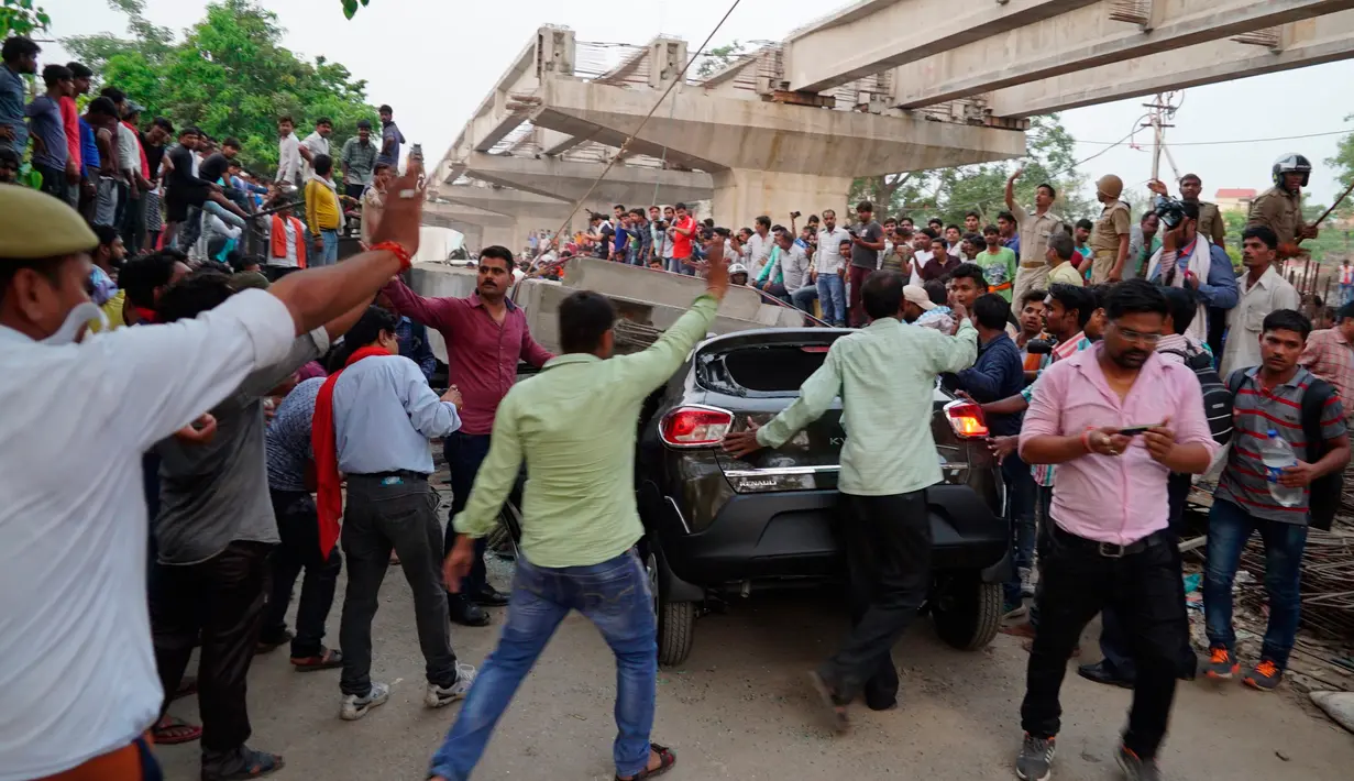Warga India berkumpul di lokasi sebuah jalan layang dalam tahap konstruksi yang mendadak runtuh di kota Varanasi, Selasa (15/5). Penyebab keruntuhan belum diketahui dan penyelidikan masih terus dilakukan. (AP Photo)