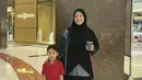 Hangout dengan anak ala Natasha Rizky. Penampilannya menarik dengan oversized shirt, rok hitam, dan hijab panjang hitam. [Foto: Instagram/natasharizkynew]