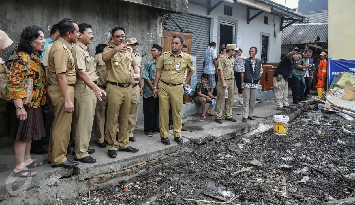 Wakil Gubernur DKI Jakarta, Djarot Saiful berbincang dengan stafnya saat meninjau rumah yang akan dibedah usai meresmikan program bedah rumah di Cilincing, Jakarta, Senin (17/4). (Liputan6.com/Faizal Fanani)