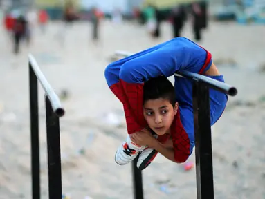 Mohammed al Sheikh menunjukkan kemampuannya di sebuah pantai di Kota Gaza, Palestina, Kamis (2/6). Dengan tinggi 1,6 meter dan berat 29 kg, Mohammed mampu menekukan tubuhnya dengan posisi yang menurut kita mustahil untuk dilakukan (REUTERS/Mohammed Salem)