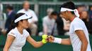 Petenis Indonesia Christopher Rungkat dan Shuko Aoyama dari Jepang saat menghadapi petenis Kroasia Nikola Mektic dan Alicja Rosolska dari Polandia pada putaran kedua ganda campuran Wimbledon 2019 di All England Lawn Tennis Club, Senin (8/7/2019). Christo/Aoyama kalah 5-7, 4-6. (GLYN KIRK/AFP)