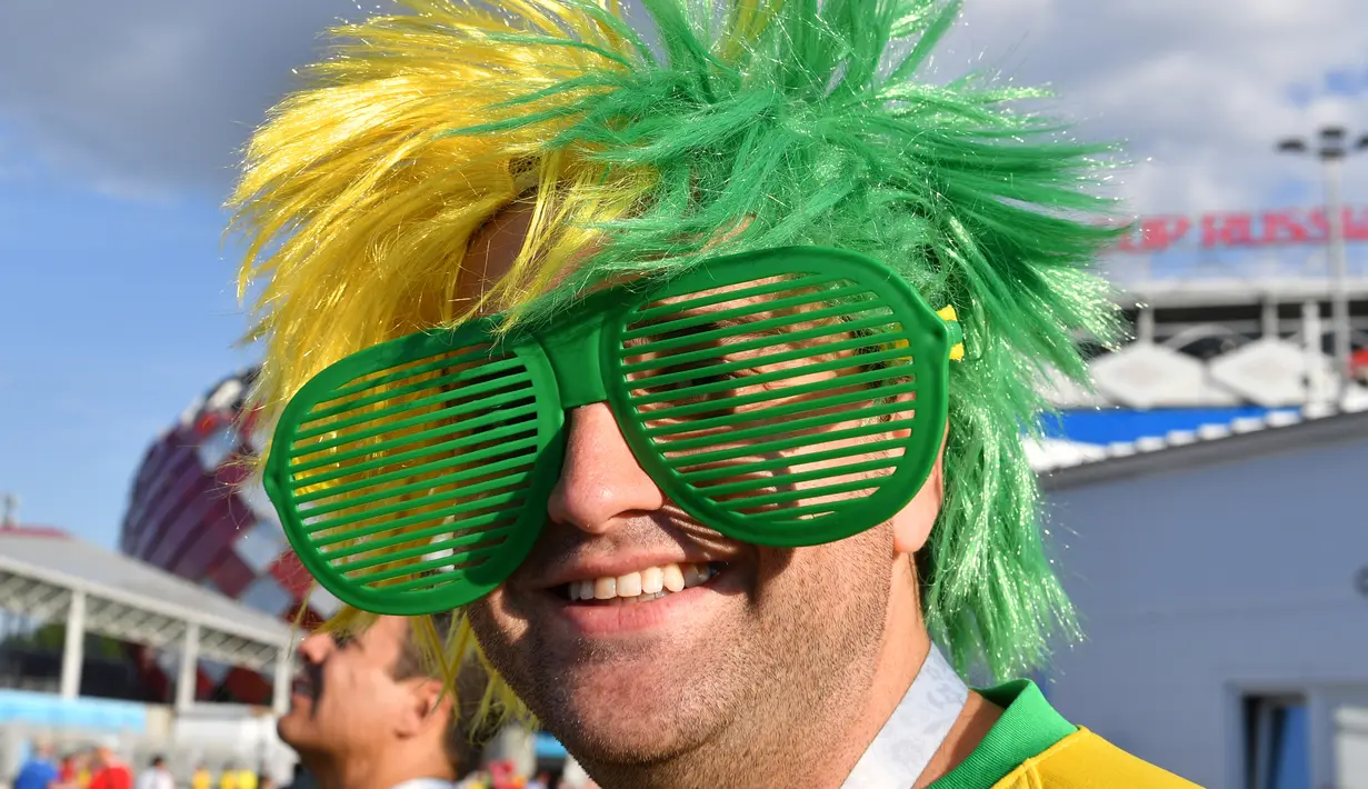 Seorang suporter timnas Brasil mengenakan kacamata unik menjelang laga terakhir penyisihan grup E Piala Dunia 2018 melawan Serbia di Stadion Spartak, Rusia, Rabu (27/6). Brasil sukses melaju ke babak 16 besar usai menang 2-0. (AFP PHOTO/Yuri CORTEZ)
