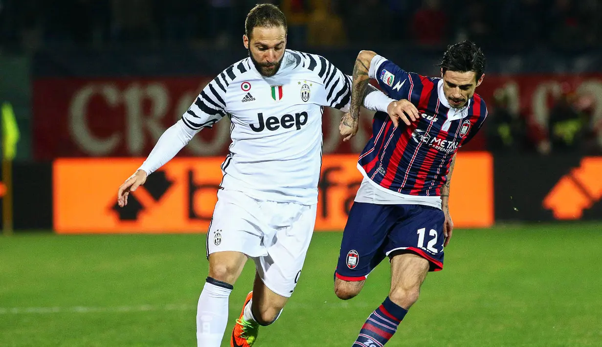 Striker Juventus, Gonzalo Higuain, berusaha melewati pemain Crotone, Adrian Stoian. Dua gol Juventus dicetak oleh Mario Mandzukic dan Gonzalo Higuain, keduanya terjadi pada babak kedua. (EPA/Albano Angilletta)