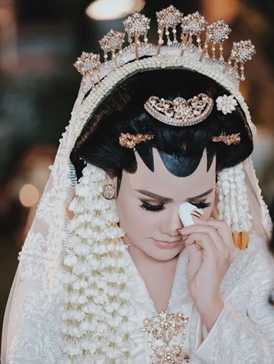 Mengenakan busana adat Jawa yang menjadi mimpinya sejak lama, Mytha tampak tak kuasa menahan air matanya. Sepertinya saat di foto ini Mytha tengah meminta restu dari kedua orang tuanya sebelum menikah. (Instagram/mytha_lestari)