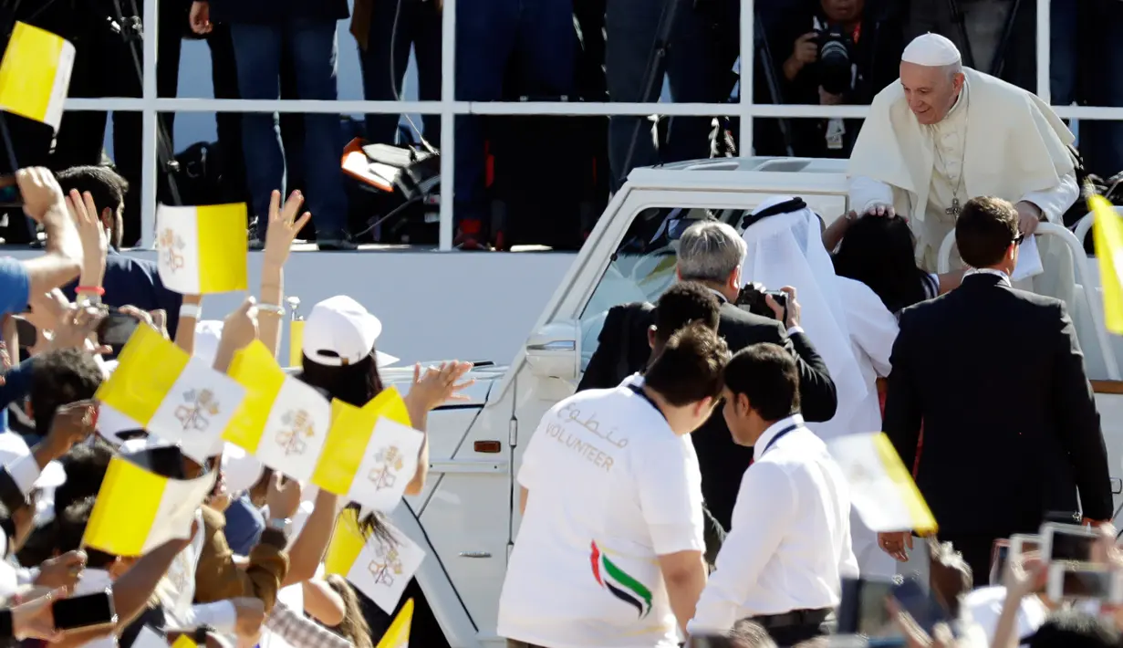 Paus Fransiskus memegang kepala seorang jemaah saat tiba untuk mengadakan misa di Stadion Zayed Sports City di Abu Dhabi, UEA (5/2). Ini merupakan kunjungan bersejarah Paus Fransiskus di Jazirah Arab. (AP Photo/Kamran Jebreili)