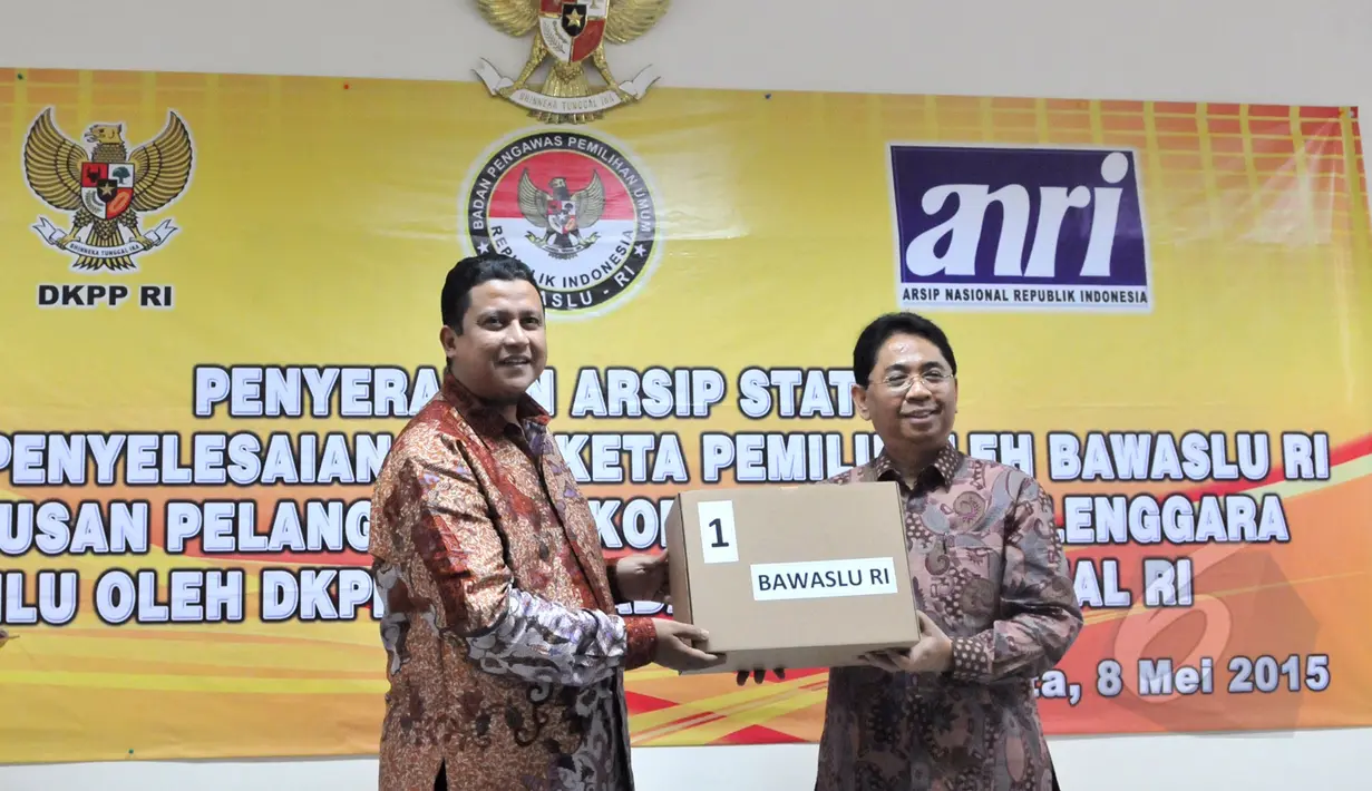 Ketua Bawaslu, Muhammad (kiri) menyerahkan arsip kepada Kepala ANRI, Mustari Irawan (kanan), dalam acara penyerahan arsip statis penyelesaian sengketa pemilu di Kantor Bawaslu, Jakarta, Jumat (8/5/2015). (Liputan6.com/Andrian M Tunay)