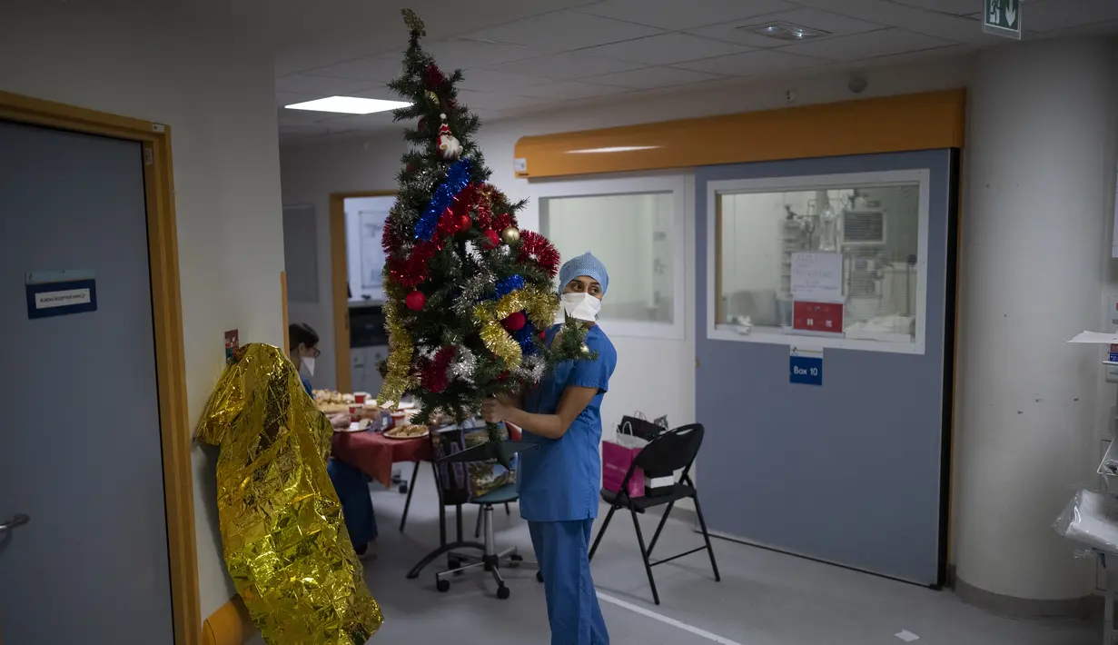 Pekerja rumah sakit Sonia Mokhtari menyiapkan pohon Natal untuk santap malam Natal di unit perawatan intensif COVID-19 di rumah sakit la Timone di Marseille, Prancis selatan, Jumat (24/12/2021). (AP Photo/Daniel Cole)