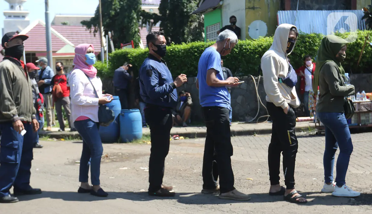 Warga mengantre untuk pembuatan dan memperpanjang SIM di mobil layanan SIM Keliling Masjid At-Tin TMII, Jakarta Timur, Kamis (4/6/2020). Direktorat Lalu Lintas Polda Metro Jaya mengoperasikan kembali layanan mobil SIM Keliling untuk mengantisipasi antrean pemohon. (Liputan6.com/Herman Zakharia)