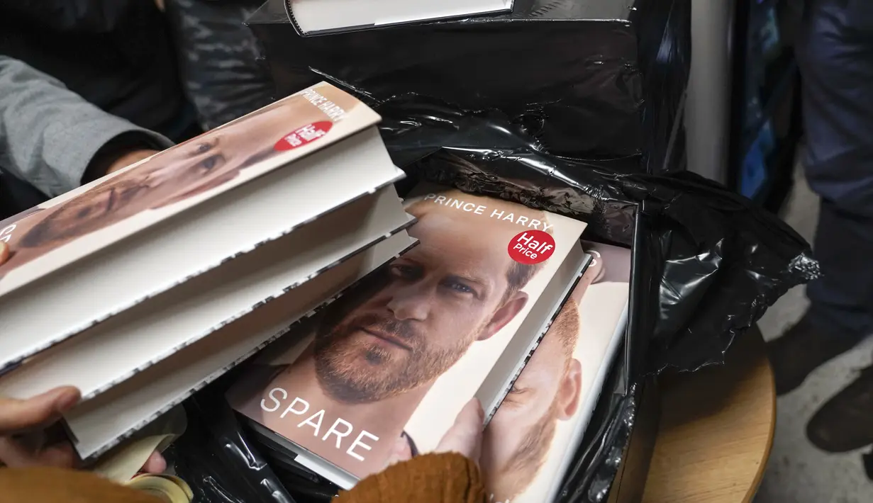 Buku baru Pangeran Harry berjudul "Spare" dipegang oleh anggota staf toko buku saat pembukaan tengah malam di London, Selasa (10/1/2023). Memoar baru Harry yang memamerkan jiwa, "Spare," telah menghasilkan berita utama yang membara bahkan sebelum dirilis. (AP/Alberto Pezzali)