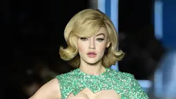 Model AS, Gigi Hadid berpose mengenakan koleksi terbaru Moschino di panggung runway Milan Fashion Week 2018, Rabu (21/2). Tampilan rambutnya dibuat bob khas Retro tahun 60-an yang disasak dan menggunakan poni. (Miguel MEDINA/AFP)