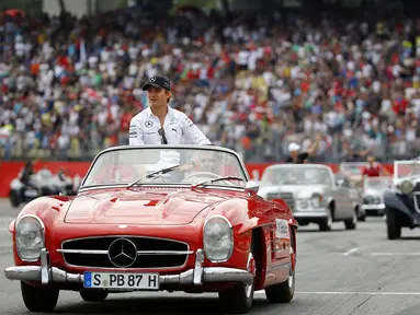 Jelang berlaga di GP Jerman, beberapa pembalap Formula Satu berparade mengelilingi Sirkuit Hockenheim menggunakan mobil antik, (20/7/2014). (REUTERS/Kai Pfaffenbach)