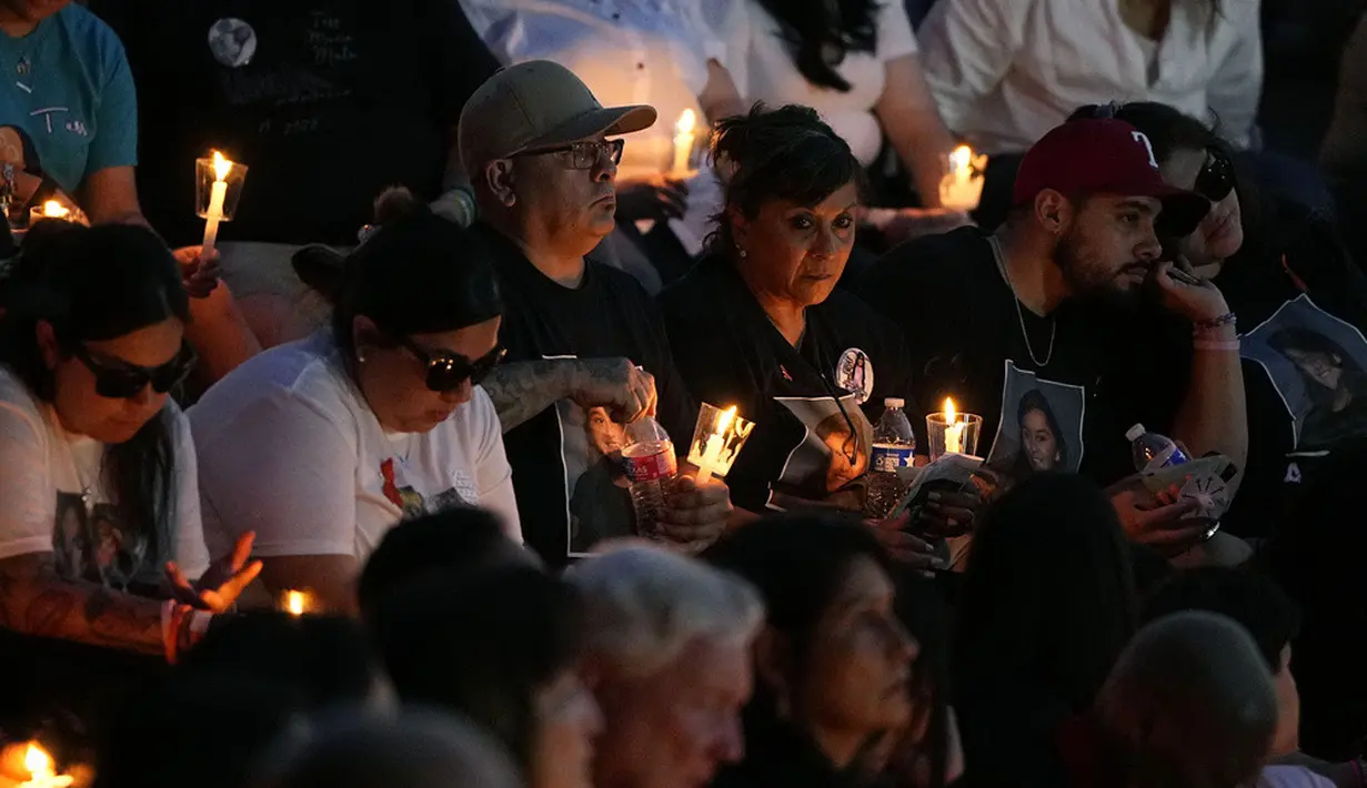<p>Kerumunan ratusan orang melepaskan kupu-kupu ke langit malam. Sementara anak-anak yang selamat menyalakan lilin pertama dari banyak lilin yang semakin terang saat matahari terbenam, ada pemimpin politik yang hadir. (AP Photo/Eric Gay)</p>