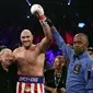 Tyson Fury (tengah) merayakan kemenangan atas Tom Schwarz di MGM Grand Garden Arena, Sabtu (26/6/2019) atau Minggu pagi WIB. (AFP/Steve Marcus)