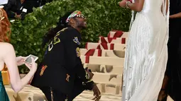 Rapper 2 Chainz berlutut saat melamar sang kekasih, Kesha Ward pada Met Gala 2018 di Metropolitan Museum of Art, New York, Senin (7/5). Chainz berlutut di karpet putih Met Gala untuk melingkarkan cincin di jari manis Kesha. (Charles Sykes/Invision/AP)