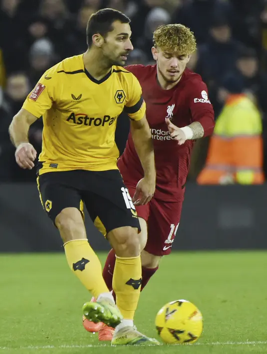 Gelandang Liverpool Harvey Elliott berebut bola dengan bek Wolverhampton Wanderers Jonny dalam partai replay putaran ketiga Piala FA 2022/2023 di Molineux Stadium, Rabu dini hari WIB (18/1/2023). Meski bermain di kandang lawan, Liverpool memulai laga dengan cukup tenang dan terus mencoba menguasai permainan. (AP Photo/Rui Vieira)