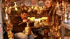Pedagang barang antik Saadoun Mansouri bekerja di tokonya di Baghdad, Irak, Rabu (20/3). (AP Photo/Hadi Mizan)