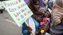 Seorang buruh perempuan Pakistan menggendong bayinya dan bergabung dalam unjuk rasa May Day, yang menandai Hari Buruh Internasional di Lahore, Pakistan, Senin, 1 Mei 2023. Para peserta unjuk rasa menuntut penerapan undang-undang ketenagakerjaan dan kenaikan upah mereka. (AP Photo/K.M. Chaudary)