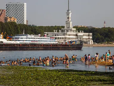 Orang-orang mendinginkan diri di Sungai Moskva pada musim panas di Moskow, Rusia, Selasa (13/7/2021). Layanan meteorologi Rusia mengatakan negara itu dapat melihat rekor musim panas terpanas, didorong oleh perubahan iklim, usai gelombang panas yang memecahkan rekor pada Juni. (DIMITAR DILKOFF/AFP)