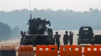 Tentara Myanmar berjaga di penghalang jalan yang diawaki dengan kendaraan lapis baja di jalan menuju gedung parlemen di Naypyitaw, Myanmar, Selasa (2/2/2021). Militer Myanmar menahan pemimpin yang terpilih secara demokratis Aung San Suu Kyi dan memberlakukan keadaan darurat satu tahun. (AP Photo)