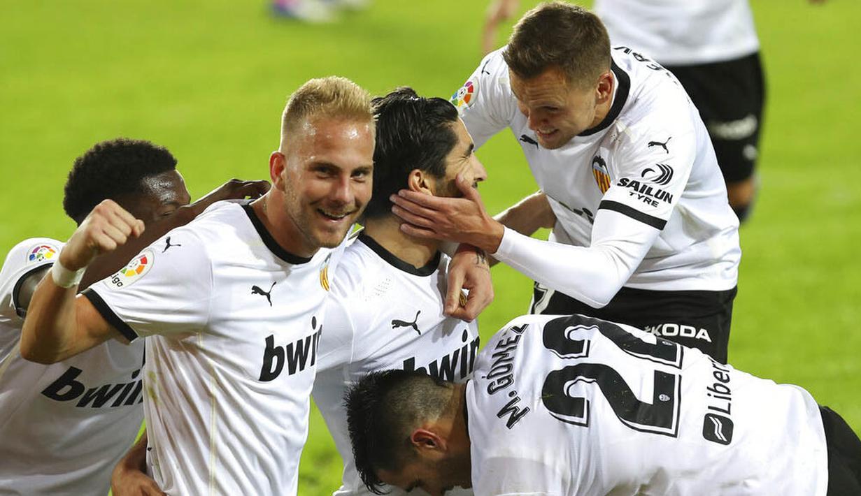 Para pemain Valencia merayakan gol yang dicetak ke gawang Real Madrid pada laga Liga Spanyol di Stadion Mestalla, Minggu (8/11/2020). Valencia menang dengan skor 4-1. (AP/Alberto Saiz)